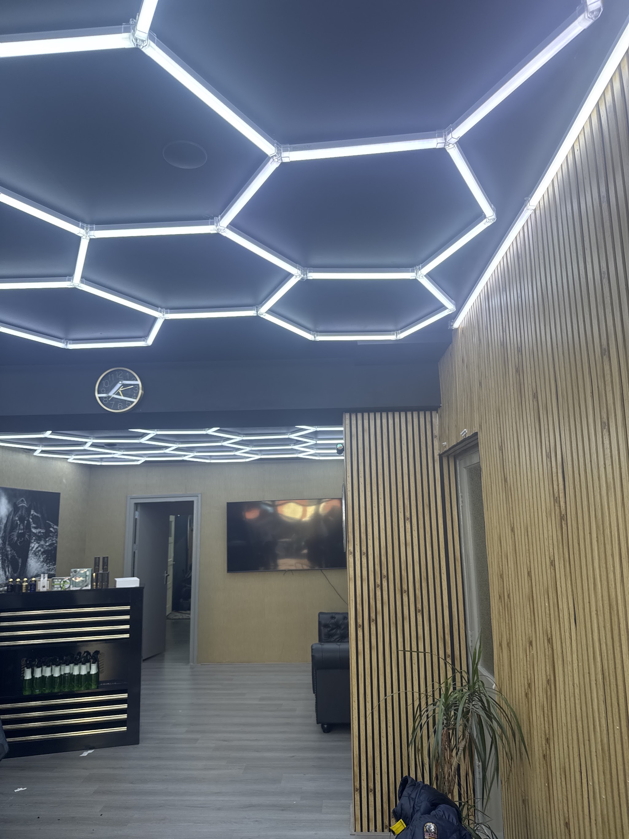 Kijkje door de zaak: het hexagon-plafond, de klok aan de muur, de balie met producten en de eiken lamellenwand